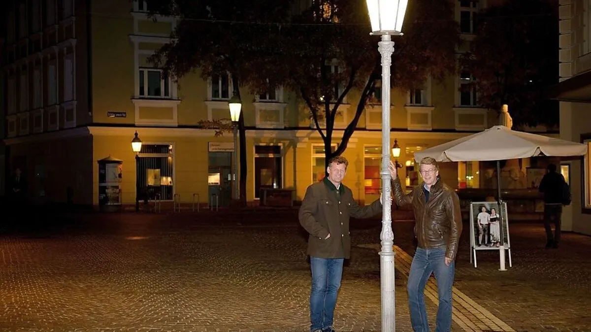 Christian Scheider und Gottfried Mirning von der Abteilung Straßenbau bei einer Laterne in der Innenstadt