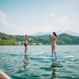 Zwei Menschen auf einem SUP im See