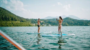 Zwei Menschen auf einem SUP im See