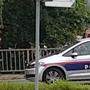 Wiener Straße nach dem Banküberfall: Ein Polizist überwacht den Autoverkehr - mit einer Maschinenpistole (links)