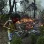 A volunteer works to extinguish a fire in Yatagan of the Mugla province, Turkey, Friday Aug. 6, 2021. Thousands of people fled wildfires burning out of control in Greece and Turkey on Friday, as a protracted heat wave turned forests into tinderboxes that threatened populated areas, electricity installations and historic sites. (Ismail Coskun/IHA via AP)