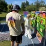 Erwachsener und Kind beim Graffiti-Sprayen
