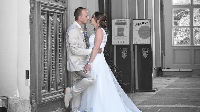 Zu sehen ist ein Hochzeitspaar, dass sich anschaut