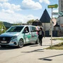 Ein Taxi an einer Haltestelle. Ein Mensch steht davor.