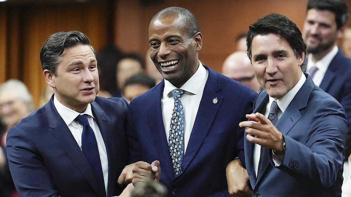 Fergus (Mitte) wird von Premier Trudeau (r.) und Konservativen-Chef Poilievre zu seinem Platz gezerrt. 