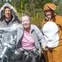 Zwei als Osterhasen verkleidete Biker und in der Mitte eine Heimbewohnerin am Motorrad