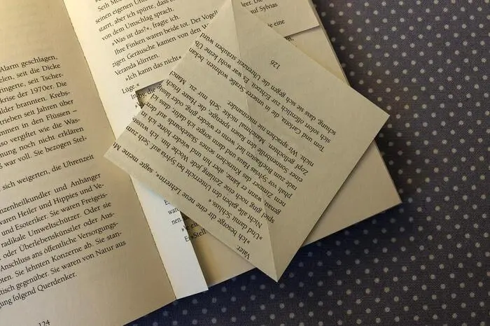 Die Buchstaben ergeben am Ende ein schönes Muster. Im ersten Schritt also einfach auf einer Seite eines Buches ein Dreieck falten, damit sich ein ordentliches Quadrat ergibt, und ausschneiden.