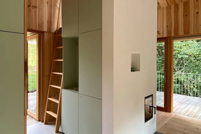 Der zentrale Kamin, dahinter rechts das Schlafzimmer, links die Leiter zum Hochbett.
