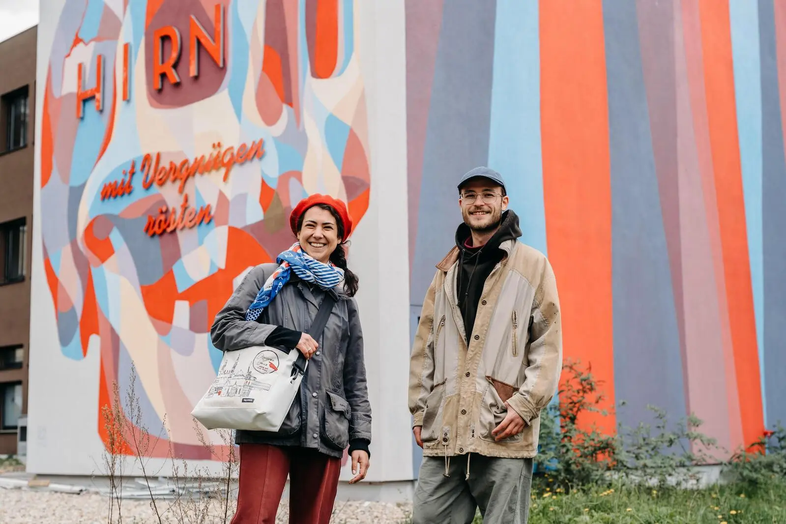 Ruth Nezmahen und Florian Perl  vor einer mit Graffiti verzierten Hausfassade