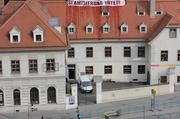 Aktivisten kletterten aufs Dach, um ein Transparent anzubringen, und verschütteten Kunstblut. Auf der Straße stand eine kleine Gruppe von Aktivisten, um ihre Kollegen zu unterstützen.