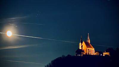 Leuchten in dunkler Nacht  | Fast scheint es, als würden sie um die Wette leuchten wollen: der Mond und die Wallfahrtskirche Judendorf-Straßengel. 