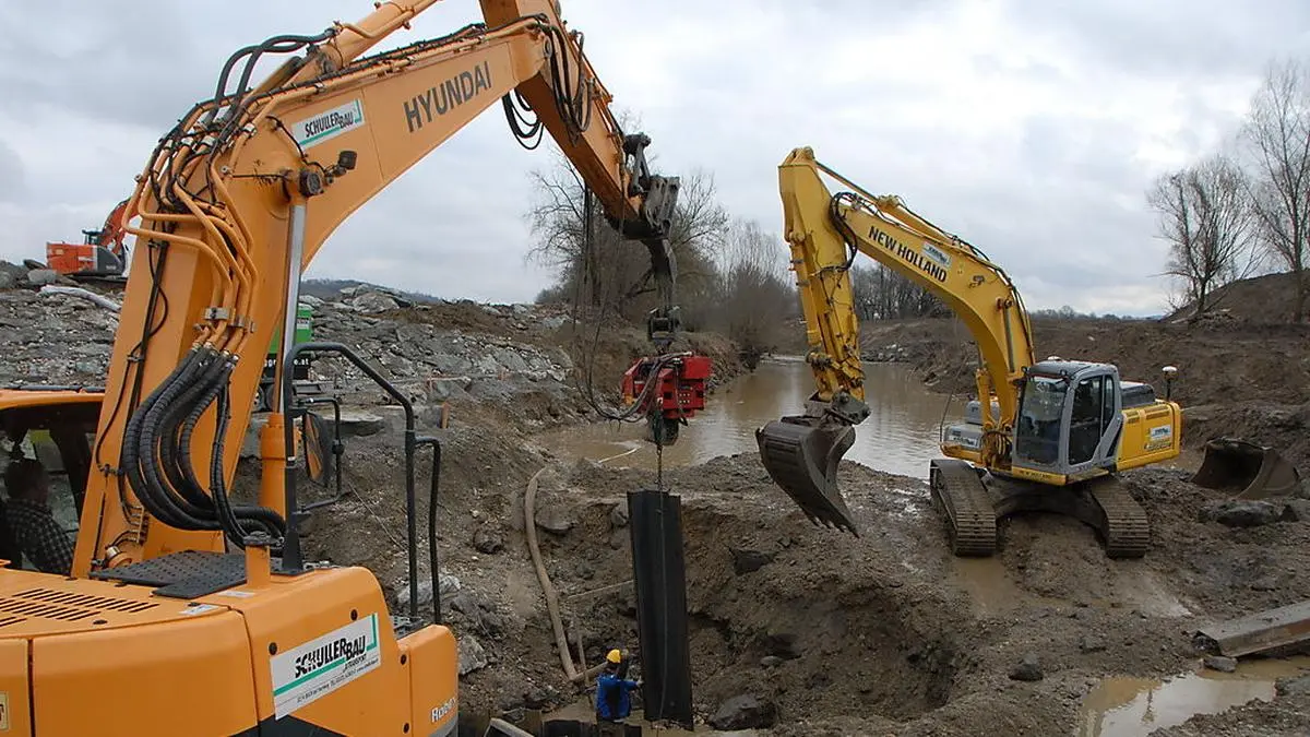 Baustelle mitten in der Raab. Einbau von Spundwänden, die das Wasser abhalten