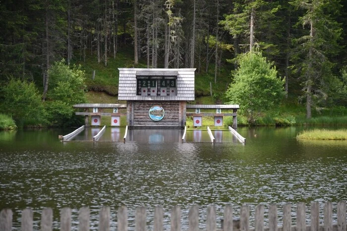 ... heißt, der Schütze schießt auf das Spiegelbild einer Zielscheibe am anderen Ufer des Sees, die Kugel prallt von der Wasseroberfläche ab und schlägt in die echte Zielscheibe ein.