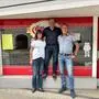 Zwei Männer und eine Frau sehen vor einem Schaufenster