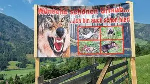 "Wünsche schönen Urlaub ... ich bin auch schon hier", ist auf dem Plakat zu lesen. Bilder von mehreren gerissenen Tieren und ein zähnefletschender Wolf sind ebenfalls zu sehen 