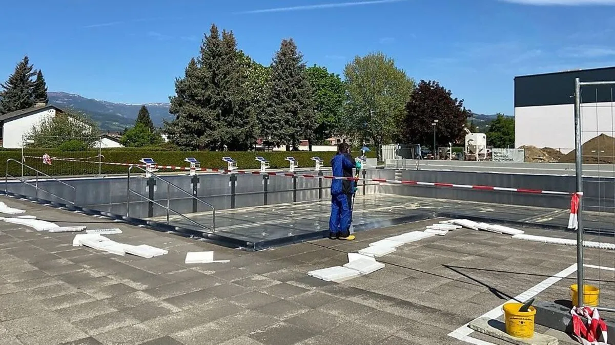 Die Reinigung des 2-Meter-Beckens. Dahinter sieht man das neue Kino, das einen Teil der Liegewiese einnimmt 