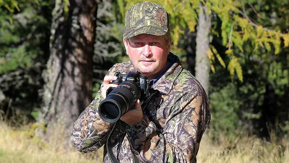 Kamera und Tarnanzug gehören zur Ausrüstung des Tierfotografen