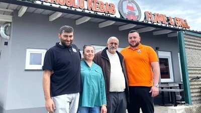 Eine Familie steht vor einem Kebab-Gebäude