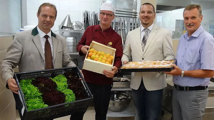 Johann Mößler, Franz Payerl, Thomas Schell und Gottfried Mandler mit heimischen Lebensmitteln in der Großküche
