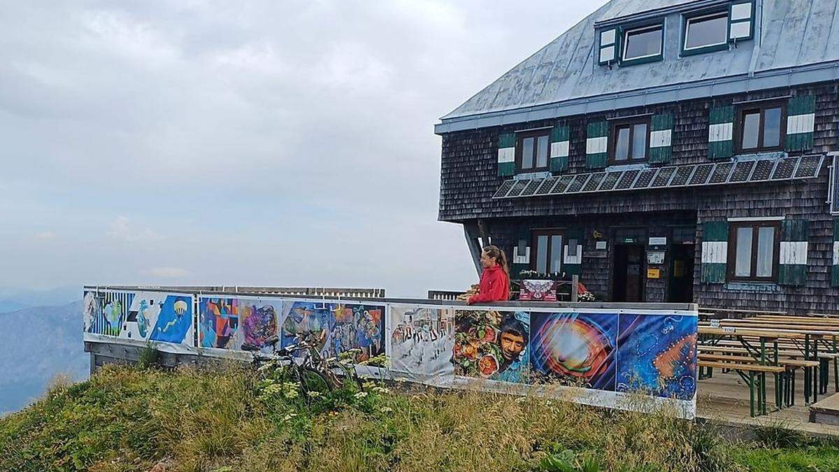 Bilder internationaler Künstlerinnen und Künstler des Projektes &quot;See the big picture&quot; hängen an der Terrassenumzäunung der Reichensteinhütte