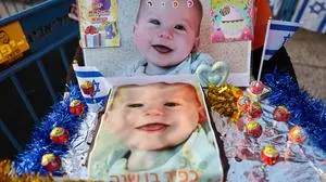 A supporter holds a cake with pictures of Kfir Bibas, the youngest hostage to be kidnapped by Hamas militants on the October 7 attack together with his mother and brother, as Israelis attend his first birthday celebration in Tel Aviv, on January 18, 2024. Kfir Bibas was born on January 18 and -- if still alive -- would be celebrating his first birthday. In November, Hamas broadcast a video announcing the death of the baby, his brother and mother, but there has been no confirmation from Israeli officials, and relatives are still clinging to the hope that they are not dead. (Photo by AHMAD GHARABLI / AFP)