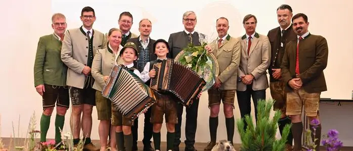 Mehrere Personen und zwei Kinder mit Instrumenten stehen auf der Bühne