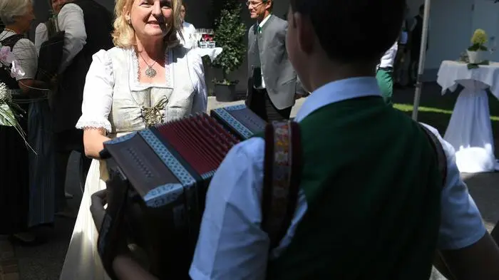 Zünftiger Empfang für die Braut im weißen Hochzeitsdirndl