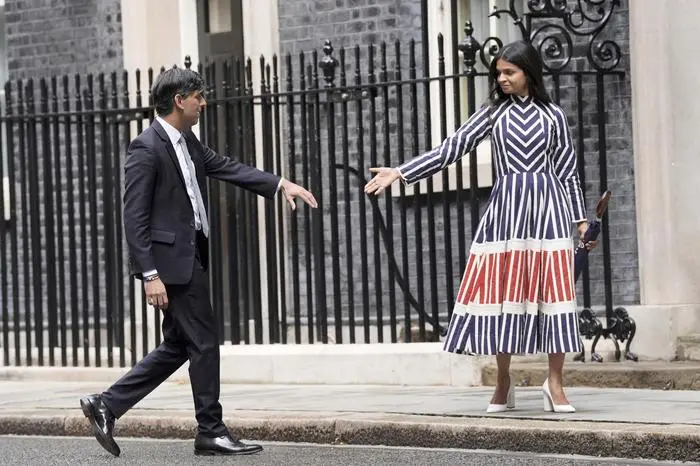 Britain's outgoing Conservative Party Prime Minister Rishi Sunak and his wife Akshata Murty walk from 10 Downing Street to a waiting car before going to see King Charles III to tender his resignation in London, Friday, July 5, 2024. Sunak and his Conservative Party lost the general election held July 4, to the Labour Party, whose leader Keir Starmer is set become Prime Minister later Friday.  (Stefan Rousseau/PA via AP)