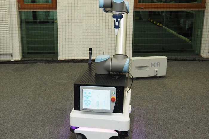Ein Roboterarm wurde mit einer Steuerungseinheit auf eine fahrende Plattform gepackt. Das ganze Projekt soll bald die "Geisterschicht" in Lagerhallen übernehmen, also selbstständig Lagerbestände prüfen, Nachschub holen, aufladen und einordnen. . .