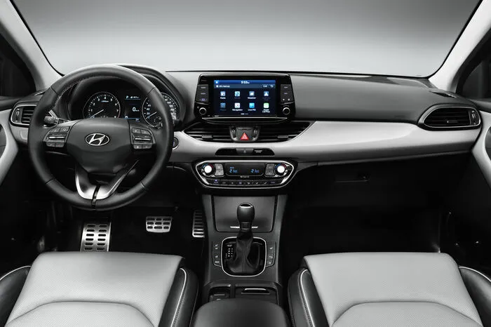 Das Cockpit ist klar und aufgeräumt: Auf dem 5-Zoll- oder dem optionalen 8-Zoll-Touchscreen auf dem Armaturenbrett sind alle Navigations- und Konnektivitätsfunktionen untergebracht. Die Bedienungsmöglichkeit für Klimaautomatik und Temperaturregelung befindet sich in der Mittelkonsole untergebracht und kann bequem über Einstellräder bedient werden – so wie es sich gehört. Um sicherzugehen, dass die Mobiltelefone der Insassen auch immer geladen sind, bietet der neue i30 auch ein kabelloses, induktives Ladegerät (Qi-Standard) für Mobiltelefone und einen USB-Port, der in der geschlossenen Mittelkonsole untergebracht ist. Das neue Navigationssystem verfügt über ein siebenjähriges kostenloses Abonnement des TomTom-Live-Services.