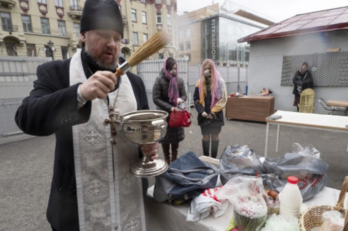 Ein orthodoxer Priester segnet traditionelle Osterkuchen und bemalte Eier, die für die Osterfeier in einem Haushaltshof der Kasaner Kathedrale zubereitet wurden.