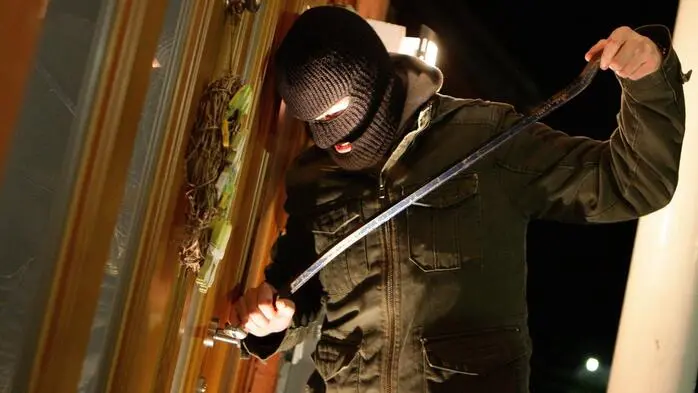 Einbrecher mit Maske und Brechstange