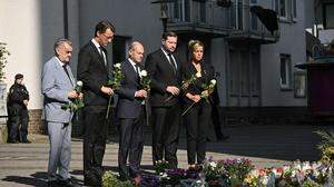 Nordrhein-Westfalens Innenminister Herbert Reul, Ministerpräsident Hendrik Wüst, der deutsche Bundeskanzler Olaf Scholz, Solingens Bürgermeister Tim Kurzbach und Vize-Ministerpräsidentin Mona Neubaur legen Blumen beim Tatort nieder.