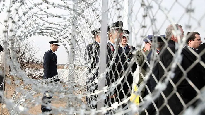 Frontex-Leute an einem Sicherheitszaun an der Grenze zur Türkei