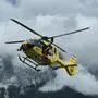 Notarzthubschrauber Christophorus 14 in der Luft vor einem Bergmassiv