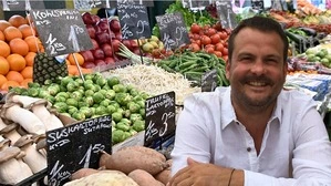 Das Bild zeigt eine Montage aus einem Gemüseregal und dem Professor für Humangeographie Ulrich Ermann