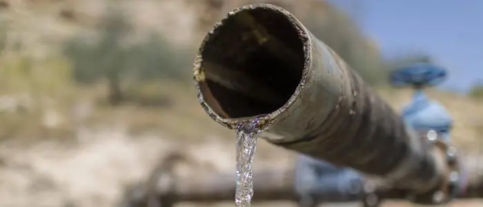 Aus einem Wasserrohr fließt ein dünnes Rinnsal