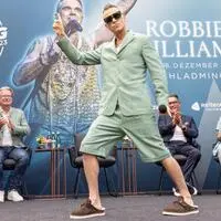 Robbie Williams, dahinter Mathias Schattleitner (TV Schladming-Dachstein), Landeshauptmann Christopher Drexler, Klaus Leutgeb und Moderator Benny Hörtnagl, bei der Ski-Opening-Pressekonferenz im Juli auf der Reiteralm