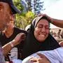 A woman mourns as she holds the shrouded body of her child who was killed during an Israeli strike on a school housing displaced Palestinians in Gaza City's Zaytoun neighbourhood on September 21, 2024, amid the ongoing war between Israel and the Palestinian militant group Hamas. (Photo by Omar AL-QATTAA / AFP)