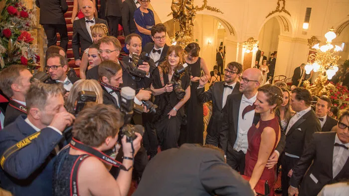 Fast schon so traditionsreich wie die Opernredoute selbst sind die Fotosessions auf der Hauptstiege in der Oper. Glanzvoll werden hier die schönen Abendroben für die Fotografen in Szene gesetzt.