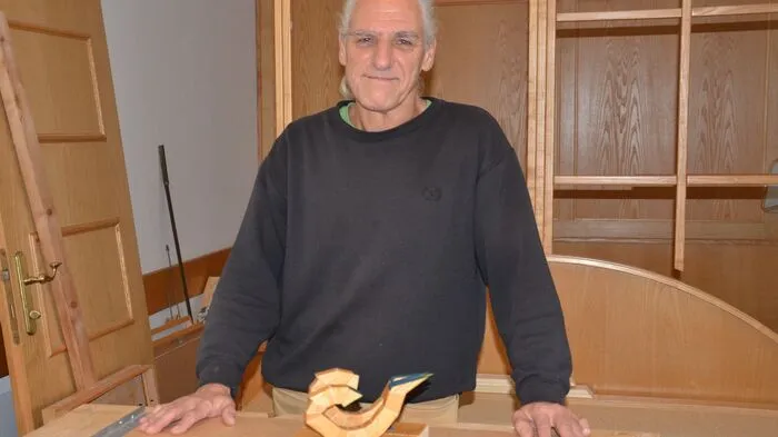Hans Egger in seiner Werkstatt mit seinem neuesten Werk: Fischen aus der Reihe der Holzsternzeichen