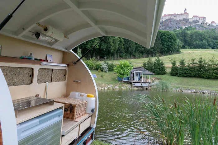 Im Heck des Anhängers verbirgt sich noch die kulinarische Seite: eine kleine Küche mit ausziehbarem Campingkocher, Kühlbox, Wasserbehälter sowie Platz für Geschirr.