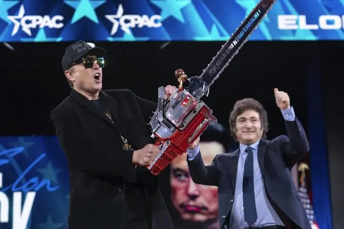 Elon Musk, left, receives a chainsaw from Argentina's President Javier Milei as they arrive speaks at the Conservative Political Action Conference, CPAC, at the Gaylord National Resort & Convention Center, Thursday, Feb. 20, 2025, in Oxon Hill, Md. (AP Photo/Jose Luis Magana)