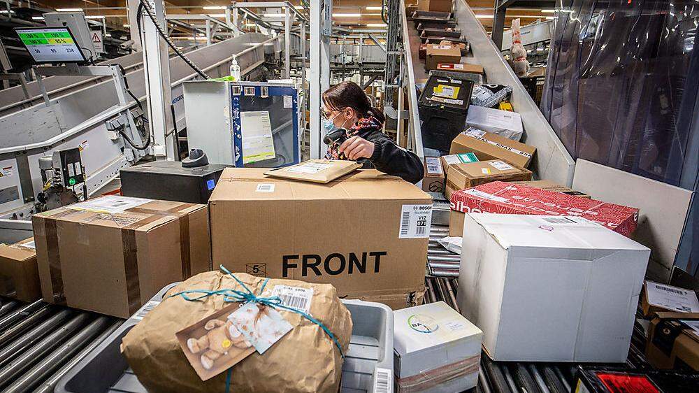 Paketberge und geforderte Mitarbeiterinnen und Mitarbeiter in den Verteilzentren der Post