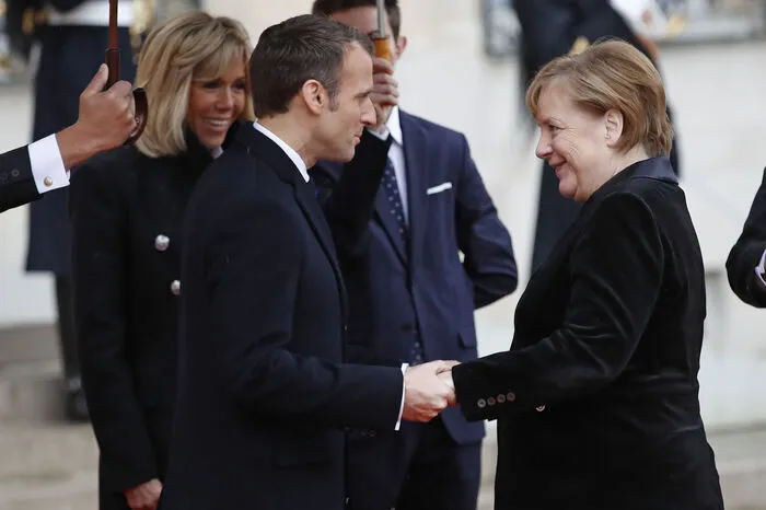 Macron heißt Angela Merkel willkommen.