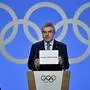 International Olympic Committee (IOC) president Thomas Bach shows the card with the name Milan/Cortina d'Ampezzo as the winning name of the 2026 Winter Olympics during the 134th session of the International Olympic Committee (IOC), in Lausanne on June 24, 2019. (Photo by Fabrice COFFRINI / AFP)