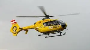 Man sieht einen gelben Rettungshubschrauber in der Luft