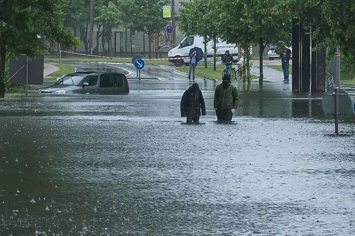 Watende Gestalten: In Teilen Berlins sind während des Tages mehr als 200 Liter Regen pro Quadratmeter gefallen. Hüfthohes Wasser und treibende Autos wurden Teil des Straßenbildes.