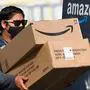 (FILES) In this file photo taken on February 02, 2021, an Amazon delivery driver carries boxes into a van outside of a distribution facility in Hawthorne, California. - A week of blockbuster earnings reports from Big Tech culminates Thursday with Amazon revealing profits from pandemic-revved online shopping and growing reliance on internet-hosted services. The e-commerce colossus is among the internet giants whose businesses thrived as precautions against Covid-19 led people around the world to go online for work, school, shopping and socializing. (Photo by Patrick T. FALLON / AFP)