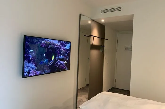 Am TV-Screen schwimmen bunte Fische im Aquarium.